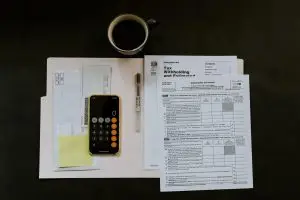 Phone next to a budget report on a black surface photo