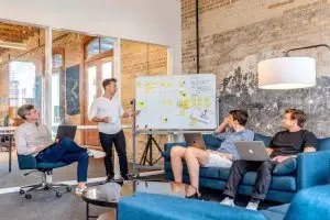 Workers discussing small business communication solutions on a whiteboard