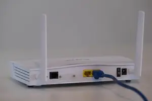 white voip router with blue cable on a white table